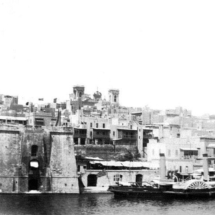 Il-Macina in 1932 showing old steam-powered tug. Mast crane is gone but old Senglea Parish Church is still standing