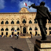 Statue of Manwel Dimech at Castille Square and the Auberge De Castille. The Prime Minister Office. in Valletta, Malta