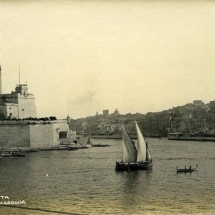 Transport, Sea - a dghajsa tal-Latini sails past St Angelo in the Grand Harbour. Image courtesy of Ray Pisani